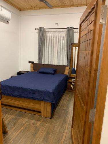 贾夫纳Chety Villa的一间卧室设有蓝色的床和窗户。