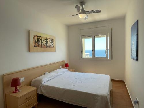 罗萨斯Marina 3的一间卧室配有一张床和吊扇