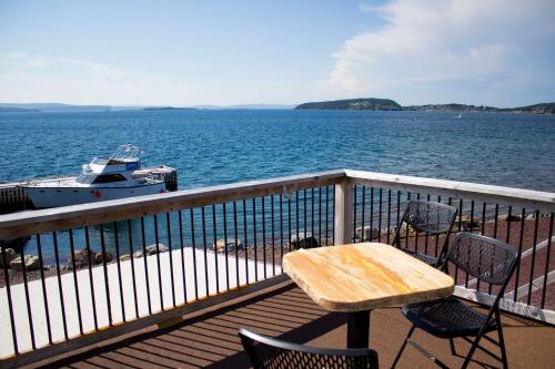 DildoDildo Boathouse Inn的船上阳台的木桌和椅子