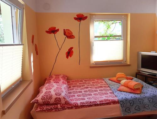 科巴里德Hiša Planica的卧室配有一张挂着红色鲜花的床。