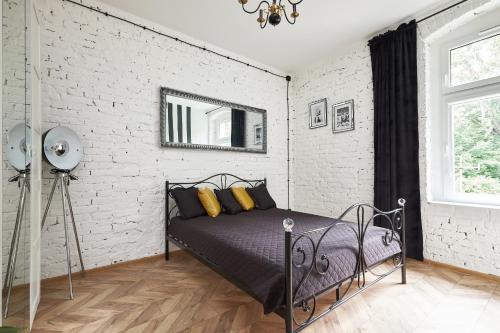GrzmiącaArt Apartment Grzmiąca的卧室配有床和白色砖墙