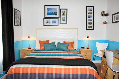 魁北克市康福特旅馆的一间卧室配有橙色和蓝色的床