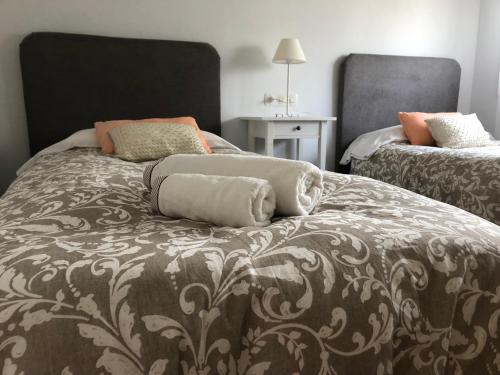 O Casal PontevedraChalet Meu Lar的一间卧室配有两张带枕头的床。
