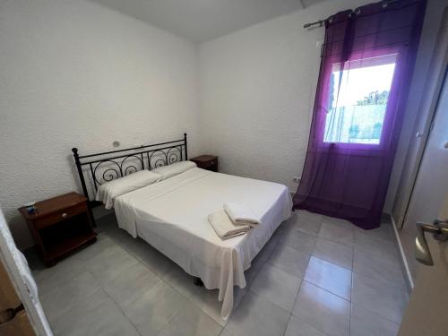 罗列特海岸Apartamentos La Isla的卧室配有白色的床和窗户。