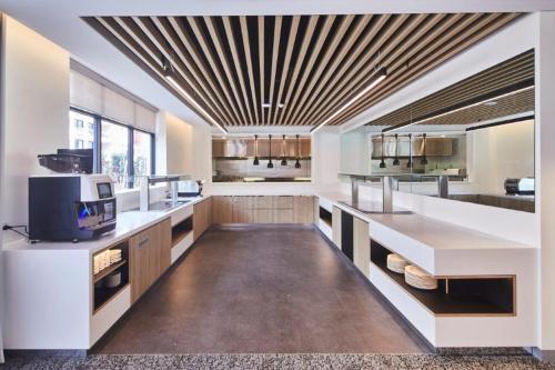 悉尼玛丽麦克罗普广场酒店的一间设有白色柜台和格子天花板的大厨房