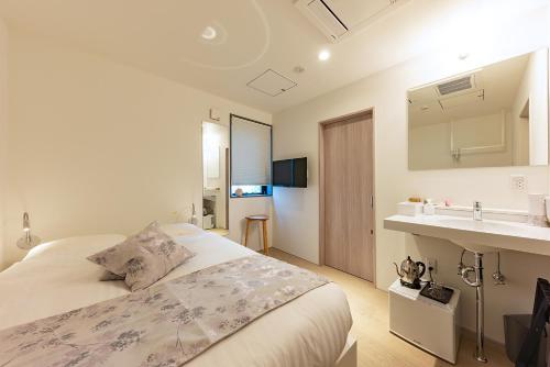 札幌plat hostel keikyu sapporo ichiba的白色卧室设有床铺和水槽