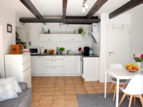 塞瓦尔兴Ferienwohnung in Seewalchen的厨房配有白色橱柜和桌子