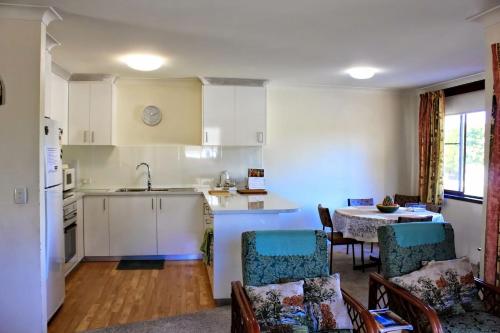 黄金海岸Sanctuary Court Unit 4的厨房以及带桌椅的起居室。
