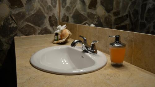 雅科Villa Creole的浴室水槽旁边放着橙色饮料