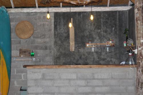 普卢坎Jungle House - surf & stay的浴室设有石墙、水槽和灯