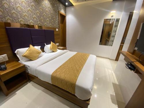 孟买Hotel BKC CROWN - Near Trade Centre, Visa Consulate的一间卧室配有一张大床和电视