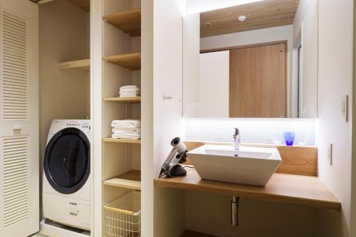 恩纳Hoshino Resorts BEB5 Okinawa Serakaki的一间带水槽和洗衣机的浴室