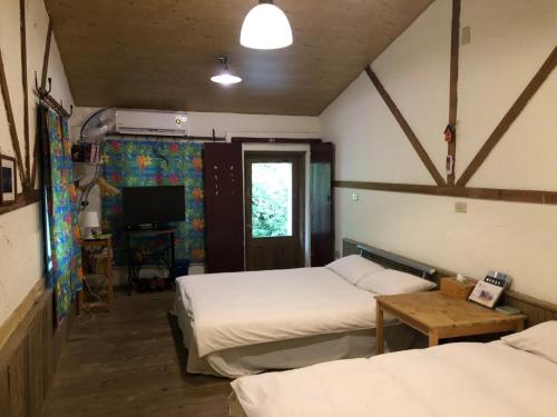 Ruifang九份金瓜石树屋137的一间设有两张床和电视的房间