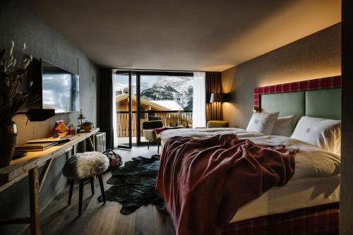 格林德尔瓦尔德Bergwelt Grindelwald - Alpine Design Resort的一间卧室配有一张床、一张书桌和一个窗户。