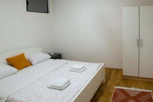 维舍格勒Apartmani Pijemont的卧室配有一张白色大床和两条毛巾