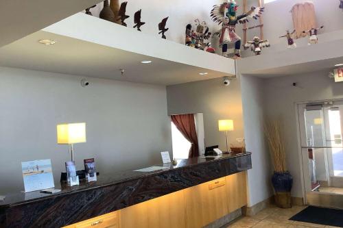 胡尔伯克Baymont Inn & Suites by Wyndham Holbrook的一间设有鸟和雕像柜台的等候室