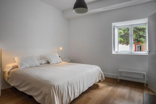 圣布里希达Albor Suites的白色卧室设有一张大床和窗户