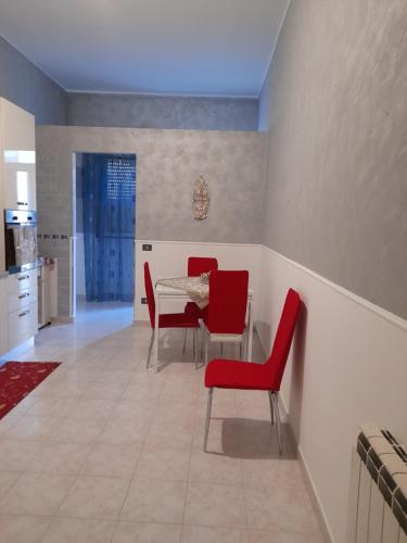 弗洛里迪亚La casa di tutti的一间带桌子和红色椅子的用餐室
