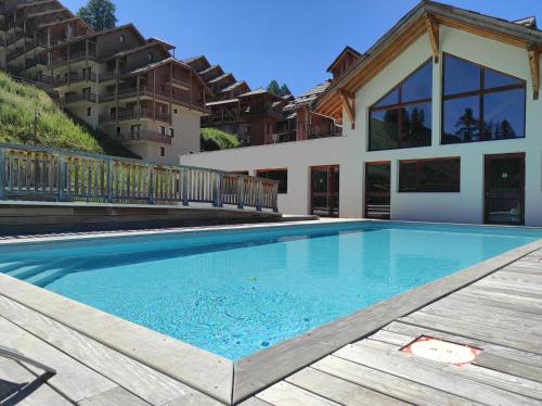 瓦尔Apt 2 chambres en duplex Chalet des Rennes Vars 2000m Piscine intérieure et extérieure的房屋前的游泳池