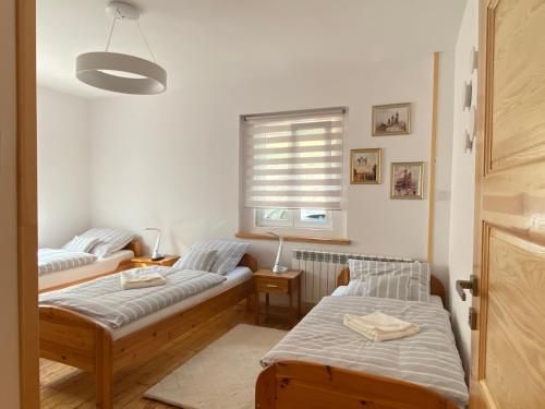 普热谢卡Chybotek Premium的一间卧室设有两张床和窗户。