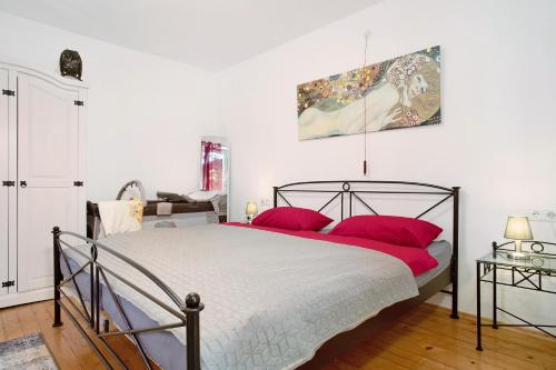 腓特烈港Haus Rosi的一间卧室配有一张带红色枕头的大床