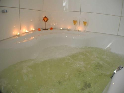 诺德霍恩Achtsamkeit - Nordhorn的浴缸装满水,装有两杯葡萄酒