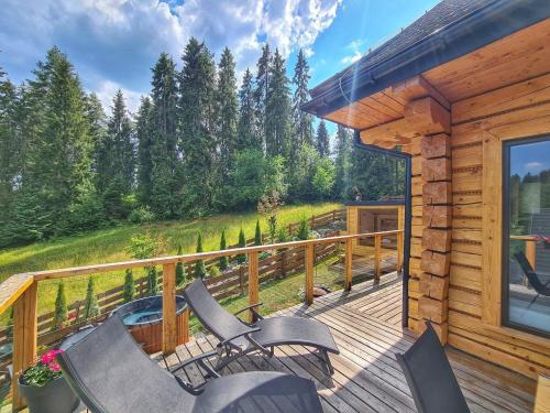 拉普斯尼恩LK Resort Łapsze domy z prywatną balią i sauną的小屋内带椅子和火坑的甲板