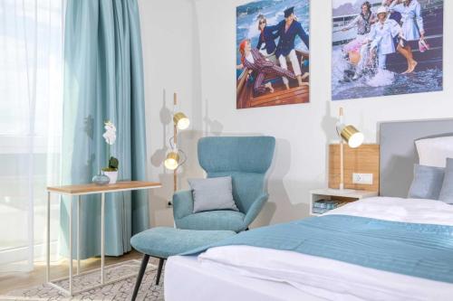 诺德霍恩NINO-Boardinghouse 16 - a69912的一间卧室配有一张床和一张蓝色椅子