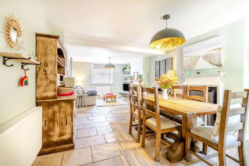 斯沃尼奇Passiflora Cottage的厨房以及带木桌和椅子的用餐室。