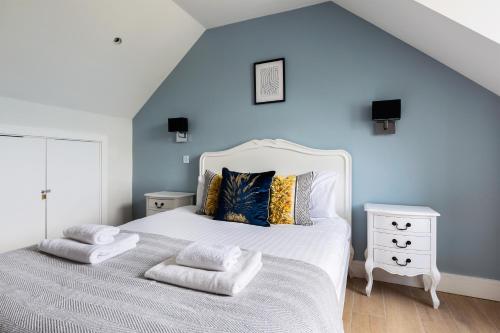 亨顿The Finchley Apartment的卧室配有白色的床和蓝色的墙壁
