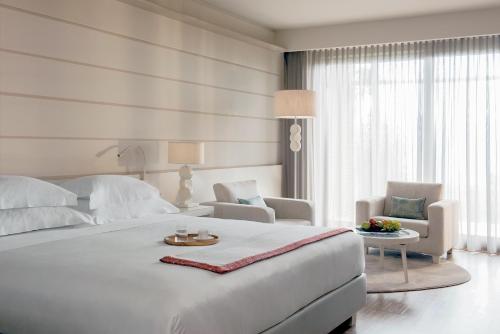加尔尼亚诺加尔达湖乐法逸酒店度假酒店及Spa的白色卧室配有白色大床和椅子