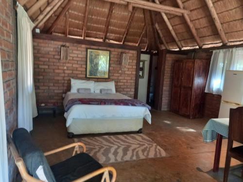 MakenaShankara Rest Camp的一间卧室设有一张床和砖墙