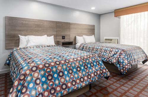 伊斯特姆蓝海豚酒店的酒店客房,配有两张带彩色床单的床