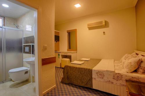 欧库卡拉AZAK BLUE OTEL的一间卧室配有一张床,浴室设有卫生间