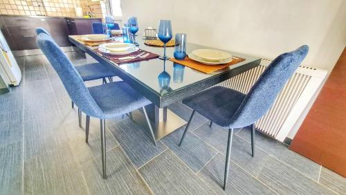 尼科西亚Luxury 2-bed apartment minutes to downtown的一张带蓝色椅子和玻璃桌的餐桌