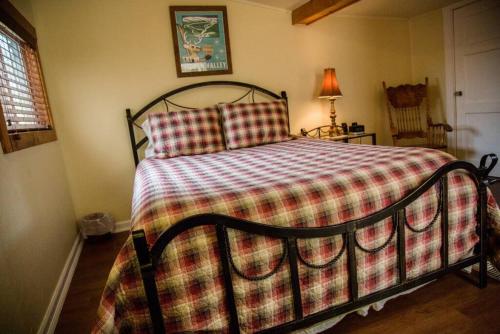 埃斯蒂斯帕克Prospect Cabin, Cozy 1-bedroom cabin with kitchen Dogs OK的卧室内一张带 ⁇ 子毯子的床
