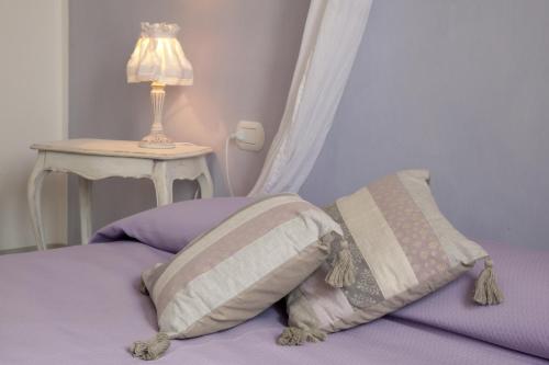 阿尔法诺纳塔科雷亚尔托农家乐的一张带两个枕头的床和一张带台灯的桌子