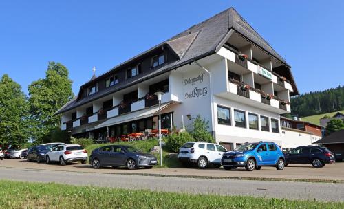 布莱特瑙Hotel Kreuz Höhengasthof的一座大型建筑,前面有汽车停放