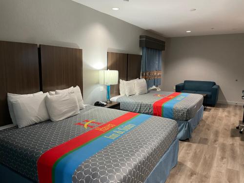 休斯顿Haven Inn & Suites Downtown Houston.的酒店客房,配有两张床和椅子