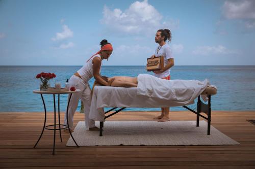 科苏梅尔Hotel B Unique的两名妇女在海滩上床上享受按摩服务