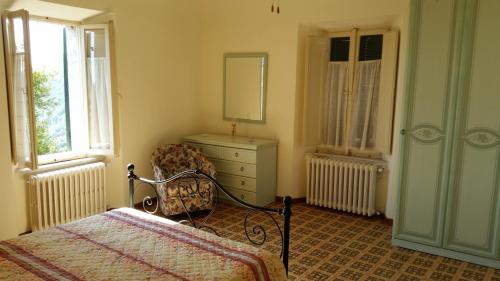 Avenale拉帕诺拉米卡公寓的一间卧室配有一张床、梳妆台和椅子