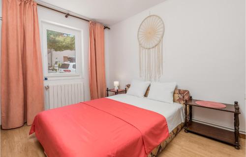 巴尔巴特纳拉布Stunning Apartment In Barbat With Kitchen的一间卧室设有红色的床和窗户。