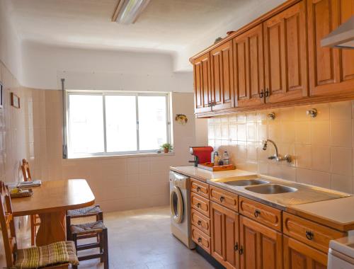 锡尼什Gustavo's Place的厨房配有木制橱柜、水槽和窗户。