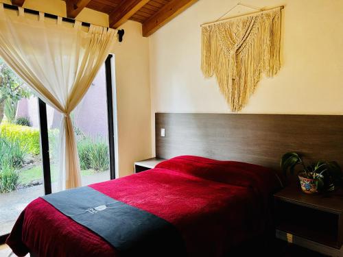 巴耶德布拉沃Casa Lunah Avandaro的一间卧室设有红色的床和窗户。