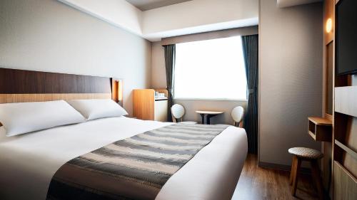东京Hotel Monte Hermana Tokyo的酒店客房设有床和窗户。