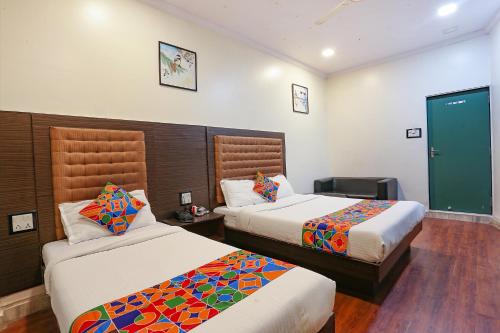 孟买Hotel Aksa Powai的一间酒店客房,设有两张床和电视