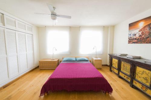塔里法Apartamento con terraza的一间卧室配有一张带紫色毯子的床