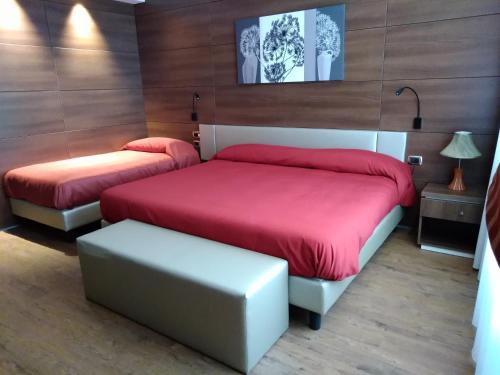 波拉Family Center Hotel的一间卧室配有两张带红色床单和凳子的床。