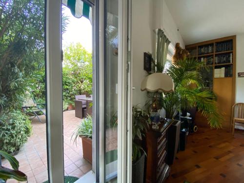 米兰Terrazza Milano Apartment的一间设有滑动玻璃门的客房,配有植物