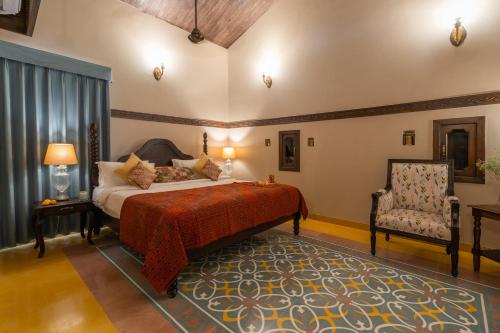 巴夫那加尔Tree of Life Darbargadh Dared的一间卧室配有一张床和一把椅子
